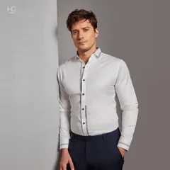 Make a statement with the perfect white shirt. This piece features subtle grey trim on the placket and cuffs, offering a modern update to a timeless wardrobe essential for any occasion.