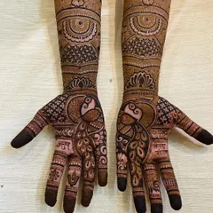 A beautiful example of symmetrical peacock designs on both palms. The peacock is a symbol of grace and beauty in Indian culture, making it a popular choice for bridal mehendi.