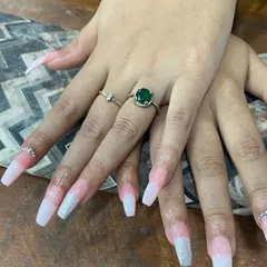 A soft and elegant look with a touch of sparkle. These long, square-shaped nail extensions feature a smooth pink-to-white ombré effect, with a silver glitter gradient on the tips for a dazzling finish.