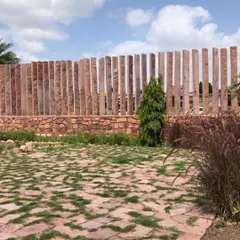 A glimpse of our project in Jodhpur, where we embraced the local landscape. This boundary wall is crafted from vertical slabs of Jodhpur stone, and the ground features a mix of stone paving and native grasses, creating a design that feels born from the earth.