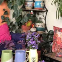 A cozy corner perfect for coffee time, decorated with fresh-cut purple asters. Flowers have a way of brightening any space and symbolizing new beginnings.