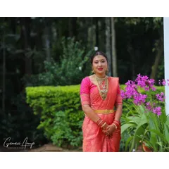An outdoor portrait of a bride on her special day. The vibrant pink saree is paired with a soft, glowing makeup look that enhances her features without feeling heavy, making it ideal for daytime events.