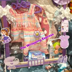 A 'Sweet Baby Girl' hamper with a purple Sofia the First theme. It's filled with colorful dresses, toys, and baby essentials, all beautifully arranged.