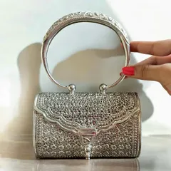 For a bold statement, a silver clutch is a must. This piece features incredibly detailed filigree work across its entire surface and a rigid, carved handle, making it a masterpiece of silver craftsmanship.