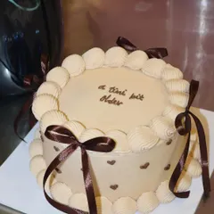 Mocha dreams baked to life. This Belgian chocolate cake is decorated with classic shell piping, tiny hearts, and rich brown ribbons for a sophisticated and indulgent treat.