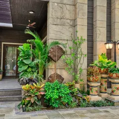 A wide shot of this home's entrance, showing how our plantscaping complements the building's architecture. The layered arrangement of crotons, palms, and other foliage adds texture and curb appeal, making the entrance a true focal point.