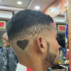 A creative combination of designs. This haircut features a heartbeat line leading into a solid heart shape, all carved into a clean fade with a sharp beard lineup.