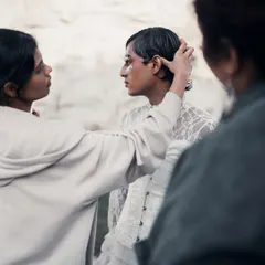 A quiet moment on set, making sure every detail of the hair and makeup is perfect for the 'White Feathers' shoot.