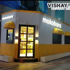 A night view of the Mokobara store, showing how crucial lighting is. The illuminated brand name and warm sconce lights create a premium feel, ensuring the store stands out and looks just as good after dark.