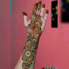 This is a classic Arabic-style 'bel' or vine design. It flows diagonally across the hand, featuring bold outlines and shaded floral and paisley elements.