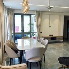 A view of the open-plan living and dining area in a Noida home. The consistent flooring and color scheme create a seamless flow between the two zones.