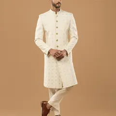 Understated elegance defined. This custom-made ivory sherwani showcases subtle, all-over embroidery on premium fabric, offering a timeless and sophisticated look for any celebration.