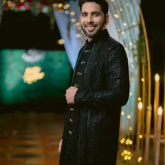 A portrait of the groom, Kartik, looking dapper and confident in his intricately designed black sherwani for his Sangeet.