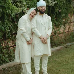 A serene portrait of a couple from a Sikh wedding, dressed in elegant white. This image captures the peaceful and spiritual nature of their celebration.