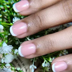 A close-up of a classic French manicure on short, natural nails. This demonstrates that the elegance of French tips is achievable on any nail length, providing a clean and polished finish.