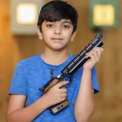 We believe in nurturing talent from a young age. This young athlete is handling a professional-grade air pistol, showcasing the safety and confidence we build in our shooters, with training open for competitors from 10 years and up.
