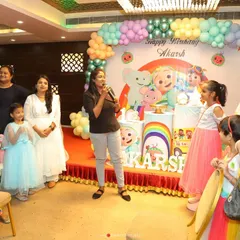 An emcee engaging with the kids at a Cocomelon party. Hiring an emcee is a great way to structure the party with games and activities, ensuring everyone has a fantastic time.