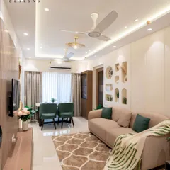 A look at a complete living and dining area we designed. We used a neutral color palette with pops of green, elegant cove lighting on the ceiling, and a mix of textures to create a space that feels both expansive and cozy.