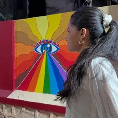 A profile view of me with the finished psychedelic mural, showing how the piece interacts with the space and creates a powerful visual impact.