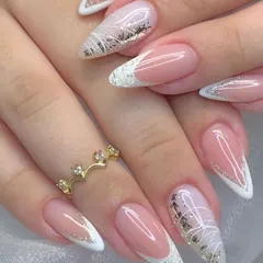 An elegant and intricate French manicure on long almond nails. This design features white tips with delicate white line art and gold and silver foil accents.