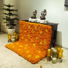 A beautiful floral rangoli made of marigolds cascading from a table holding the idols. This traditional element, surrounded by candles, brought a warm and festive spirit to the office space.