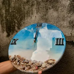 This close-up shot of the ocean wall clock highlights the glossy, mirror-like finish and the texture of the embedded shells. It's a piece that invites you to look closer.