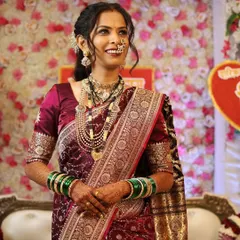 The radiant smile of a happy Maharashtrian bride. Her makeup is kept traditional and elegant, with a focus on glowing skin to match her beautiful silk saree and gold jewelry.