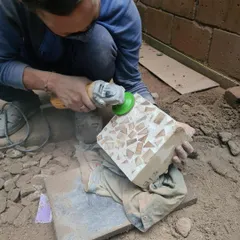 The process of grinding down the surface of our experimental wood-waste concrete block to expose the wood chips embedded within. This creates a unique, terrazzo-like finish.