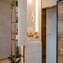 A modern take on a serene puja corner, this design uses a CNC-cut jaali door to conceal the sacred space. Backlighting reveals an Om and lotus motif, blending tradition with contemporary aesthetics.