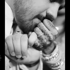 A tender and classic black and white shot focusing on the details of an engagement. The groom kissing his fiancée's hand, adorned with henna and the engagement ring, is a timeless expression of love and respect.