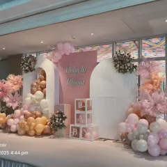 Another angle of the "Baby in Bloom" setup, showing the full scale of the stage design. The combination of balloon cascades, floral pieces, and 'BABY' blocks creates a stunning focal point.