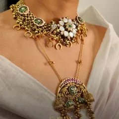 A layered neckpiece that speaks louder than words. This unique piece combines a floral choker with a longer pendant necklace featuring elephant motifs, blending different traditional styles into one cohesive design.