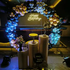 My services are perfect for adult milestone birthdays in any setting, including pubs and lounges. This moody and elegant setup uses a black and gold balloon arch over pedestals, with a custom neon 'Happy Birthday' sign and dramatic lighting to create a sophisticated party atmosphere.