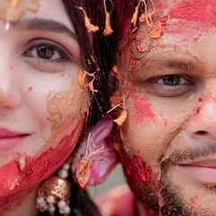 An artistic split-face portrait from a Haldi ceremony. This creative close-up captures the aftermath of the celebration, with turmeric and flower petals adorning their faces, symbolizing their shared joy and the beginning of their new life.