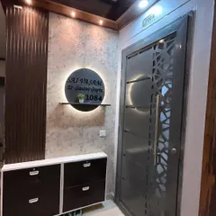 Another view of the entrance design, showing the combination of a metal security door with a geometric pattern and the warm, inviting lighting of the foyer.