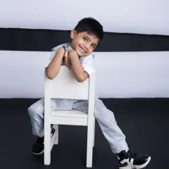 Leaning back with a cool, relaxed smile. This shot perfectly captures his charming and easy-going personality.