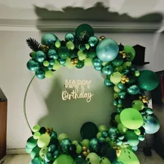 A clear, front-facing view of the green balloon ring with a "Happy Birthday" neon sign.
