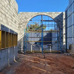 Another view of the gallery's construction, showing the scaffolding that supports the creation of the large, round window. This is the skeletal phase where architectural ideas become physical form.