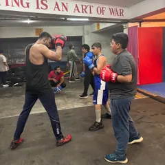 I provide direct feedback and instruction during our group sessions. Here, I'm coaching a student on his form and defense during a sparring simulation, ensuring he learns to react effectively.