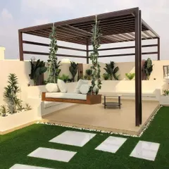 This spacious terrace combines artificial turf with a raised deck, featuring a beautiful hanging swing sofa under a sturdy pergola. The design creates distinct zones for lounging and greenery, making it a versatile family space.
