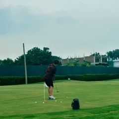 A golfer practices his putting stroke on our spacious green, surrounded by the beautiful scenery of the camp.