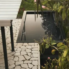 The black mirror-like pool at Pavilion House, an elevated jewel that reflects the architecture and the sky. This feature was a key part of the design, creating a point of still symmetry and a place for quiet contemplation within the natural setting.