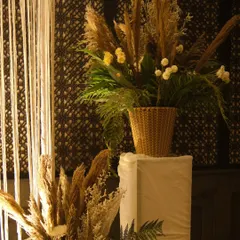 A close-up of a floral arrangement used in our boho-themed decor. It features dried pampas grass and other natural elements set against a dark, patterned backdrop, creating a rustic yet chic look.