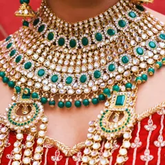 A close-up shot of a magnificent bridal necklace set, showcasing the detailed craftsmanship of the kundan and emerald jewelry.