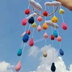 My cloud and raindrops cradle hanging is perfect for a peaceful nursery. Soft grey clouds hang above a shower of colorful raindrops, creating a beautiful visual for your little one.