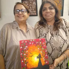 Two friends enjoying an art session together. My studio is a place where you can relax, create, and connect with others. Here they are, proudly displaying the beautiful sunset painting they created.