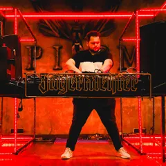 Behind the decks at a Jägermeister event. The red lights and intense atmosphere set the stage for a fiery, high-energy set.