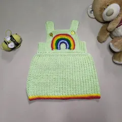 The Lucky Rainbow Dress is such a happy piece. Made with a soft green cotton yarn and a vibrant rainbow applique, this overall-style dress is both comfortable for playtime and cute enough for any special day.