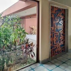 A door is a portal, and this one makes a statement. This custom-designed door features a bold, abstract pattern in orange metal layered over a vibrant blue background, turning an entryway into an unforgettable artistic moment.