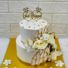 Simple elegance for a special announcement. This two-tiered "Just Engaged" cake features a clean white finish, delicate sugar flowers, and gold accents for a timeless look.